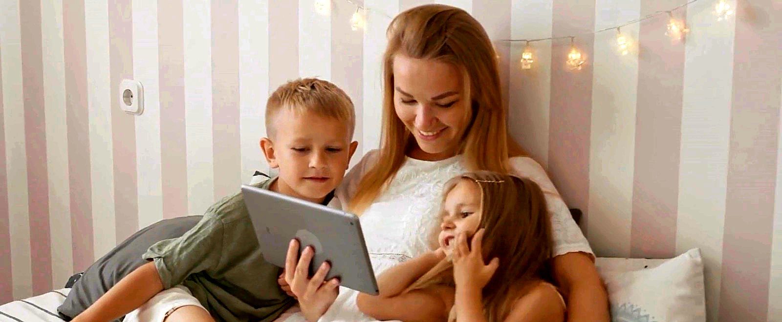 Barnvakt som läser tillsammans med två barn